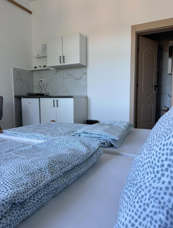 two beds in a white room with white cabinets at Apartman Milanović in Pribojska Banja