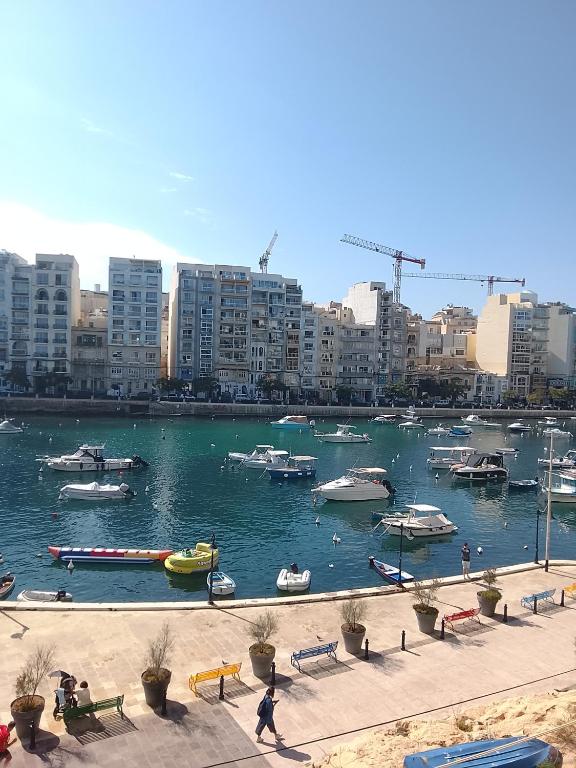 a harbor with boats in the water in a city at Sorrento in St. Julianʼs