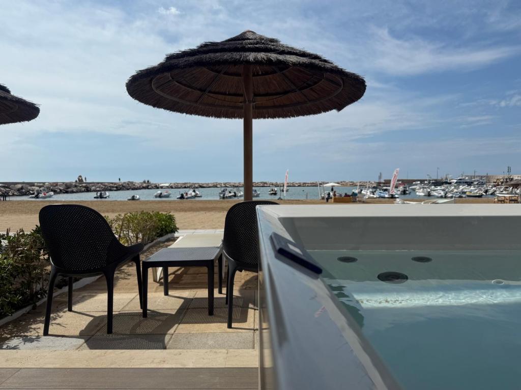 a table and chairs with an umbrella next to a swimming pool at Sea Emotions Suite in Peschici
