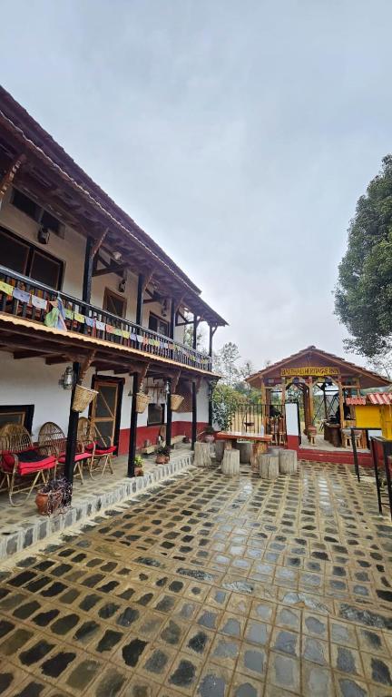 a courtyard of a building with tables and chairs at Balthali Heritage Inn in Panaoti