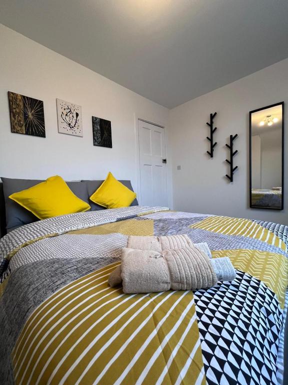 - une chambre avec 2 lits et des oreillers jaunes dans l'établissement 2-Bed Family House Nr Nottingham City Hospital, Arnold, Mansfield with Free WiFi, à Nottingham