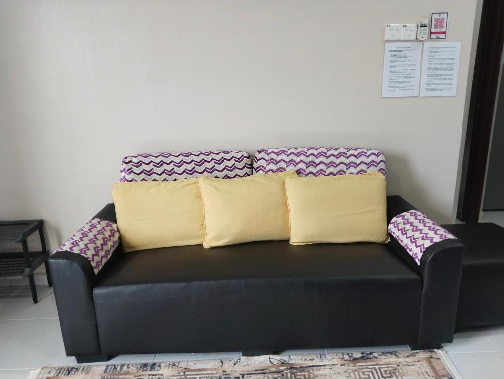 a black couch with two pillows on top of it at Homestay Salsabila Langkawi in Kampung Padang Masirat