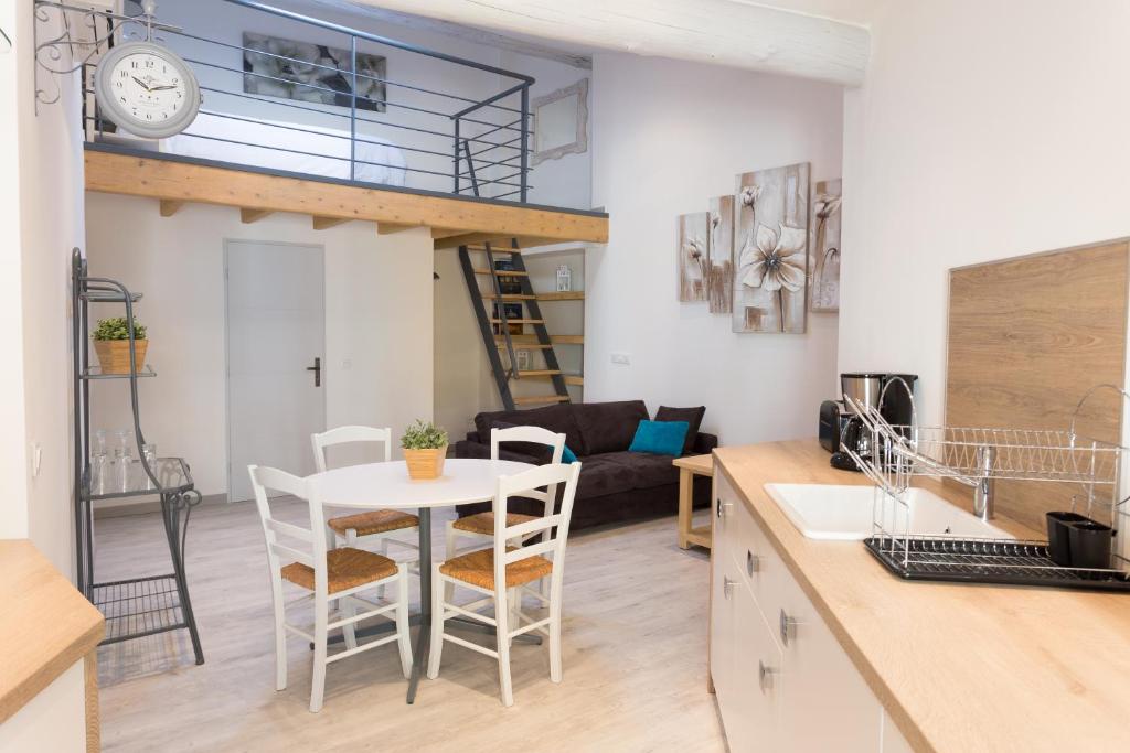 een keuken en een woonkamer met een tafel en stoelen bij Grand studio République in LʼIsle-sur-la-Sorgue