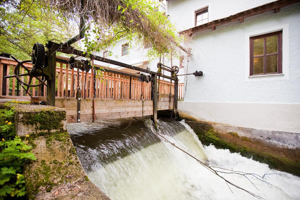 una pequeña cascada frente a una casa en Hotel Schleuse en Múnich