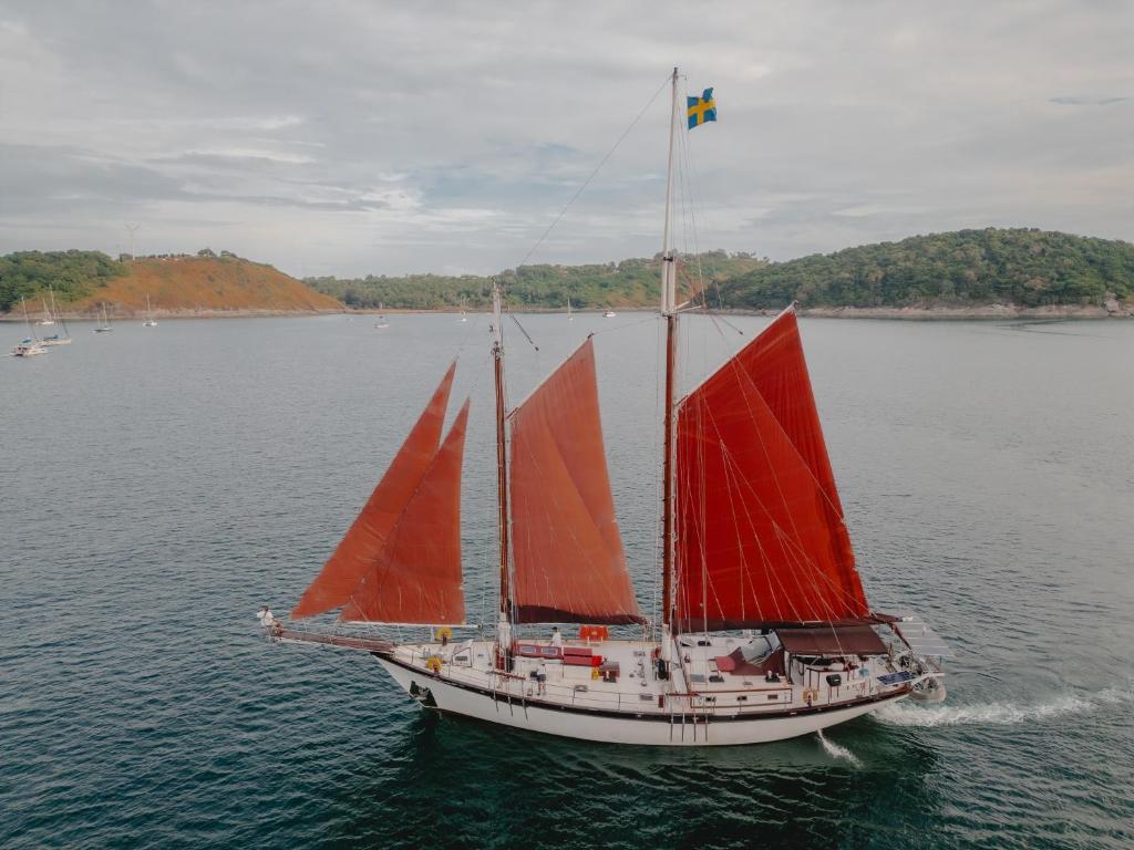 un velero con velas rojas en el agua en Sjostrom, en Ban Ko En