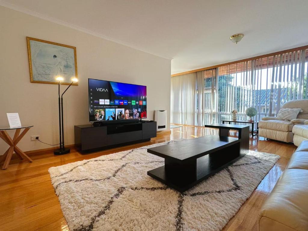 a living room with a couch and a tv at Morden Sandy Bay Home The Ultimate Base in Hobar in Sandy Bay