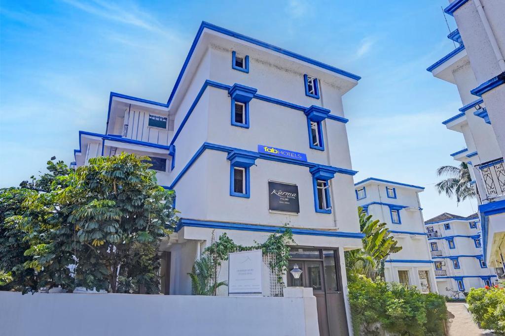 a large white building with blue trim at Via PRG Park in Benaulim