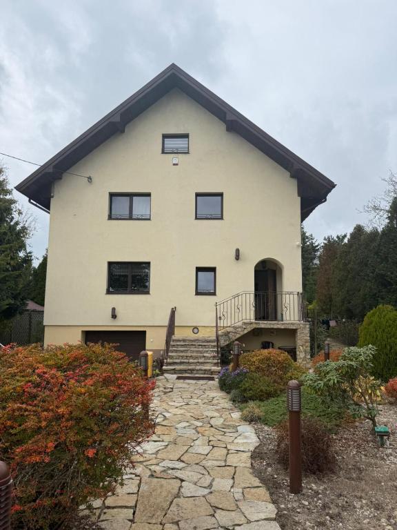 a large white house with a stone walkway in front at BIZAR Hostel in Sadowa