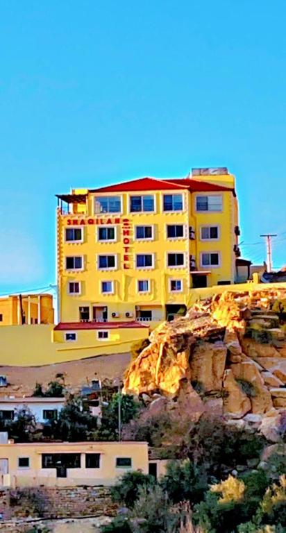 a yellow building sitting on top of a mountain at Shaqilath Hotel in Wadi Musa