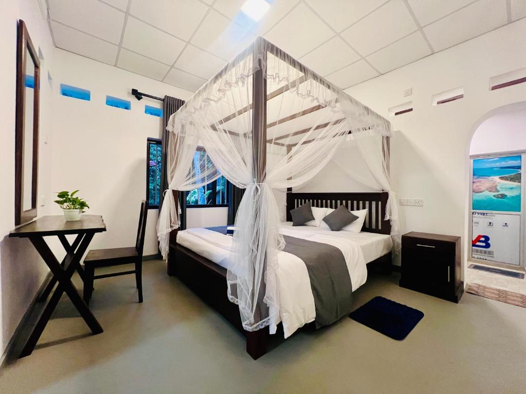 a bedroom with a bed with a canopy at Villa Eco Stay in Tangalle