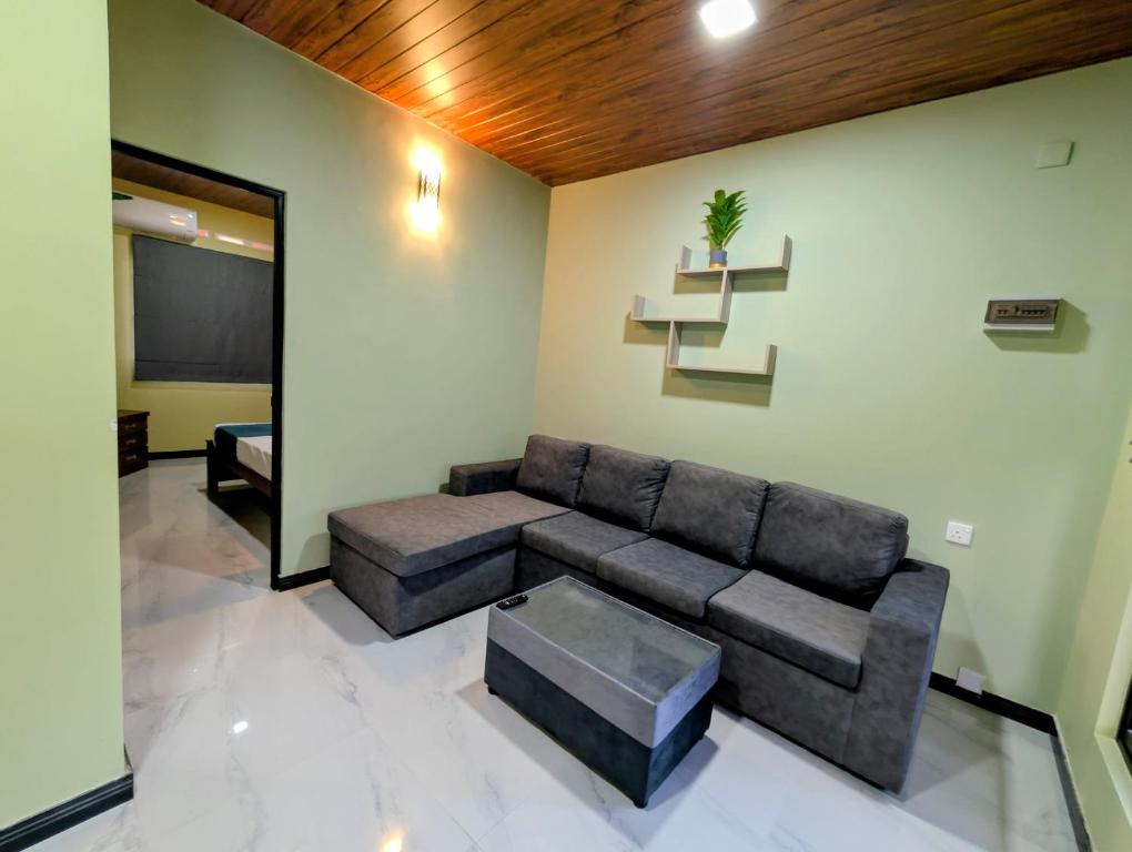 una sala de estar con un sofá y una mesa en Greenlight Stay, en Ambalangoda