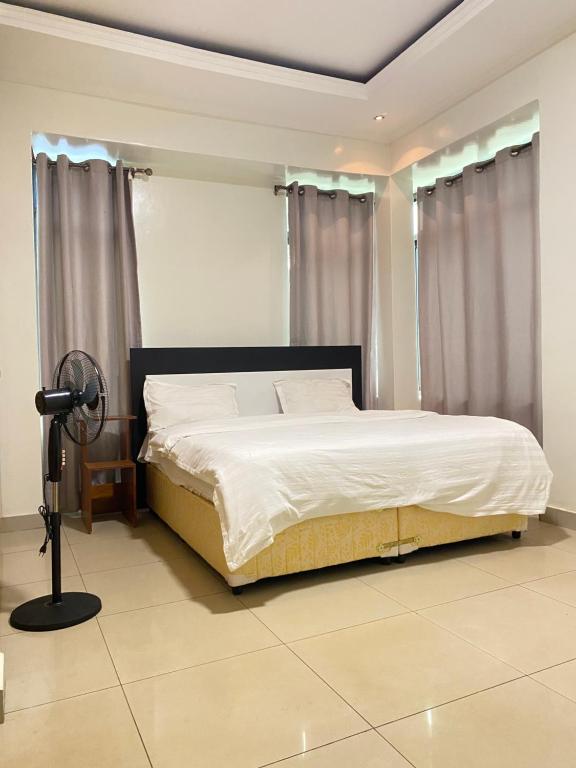 Un dormitorio con una cama y una lámpara. en KIGALI SECRET STAY AND ViLLA, en Kigali