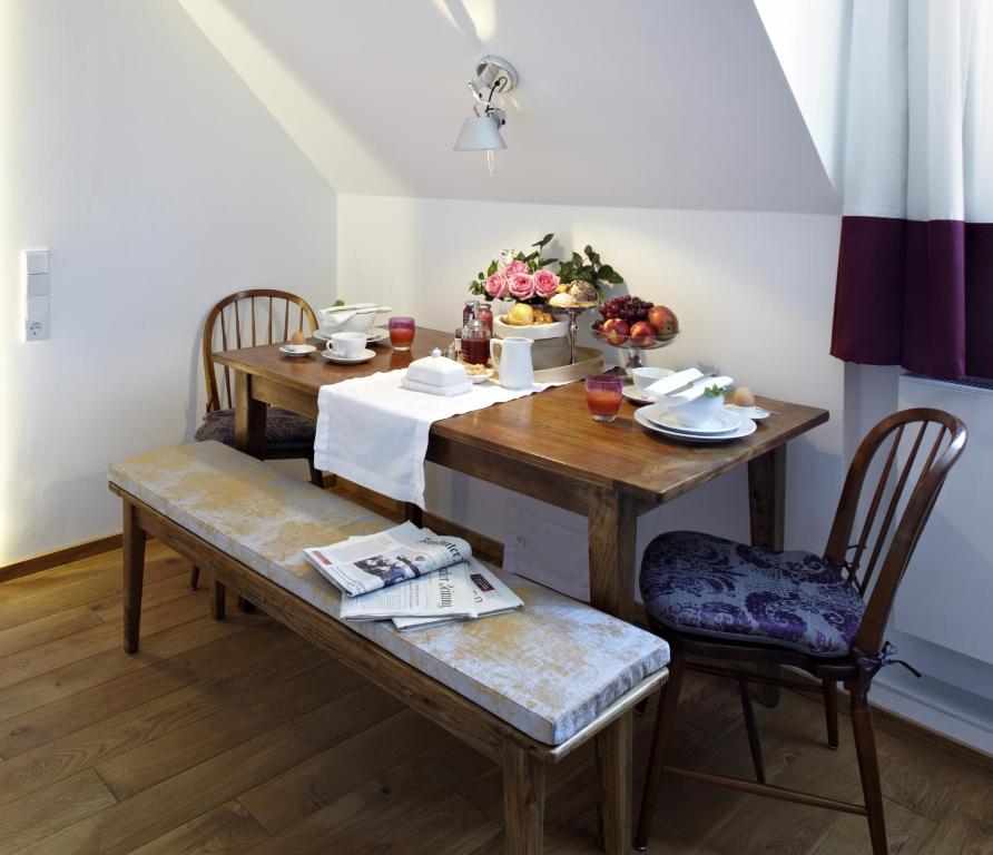a dining room table with two chairs and a table with at KönigsSCHLAF No5 - Barrierefrei, chic & gemütlich in der Altstadt in Konstanz
