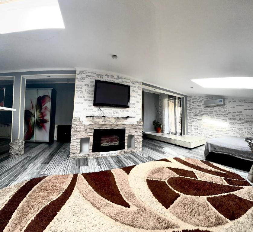 a living room with a fireplace and a flat screen tv at Stone City Apartment in Park Zone in Kamianets-Podilskyi