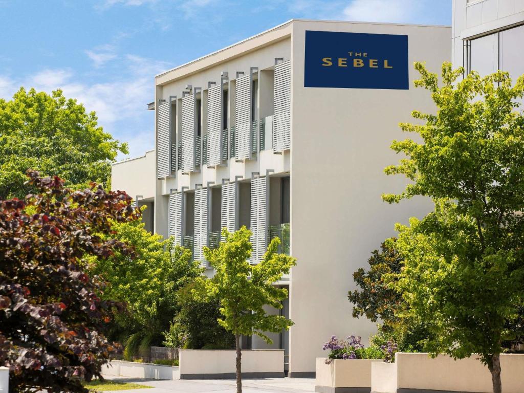 un bâtiment avec un panneau bleu sur le côté dans l'établissement The Sebel Melbourne Kew, à Melbourne