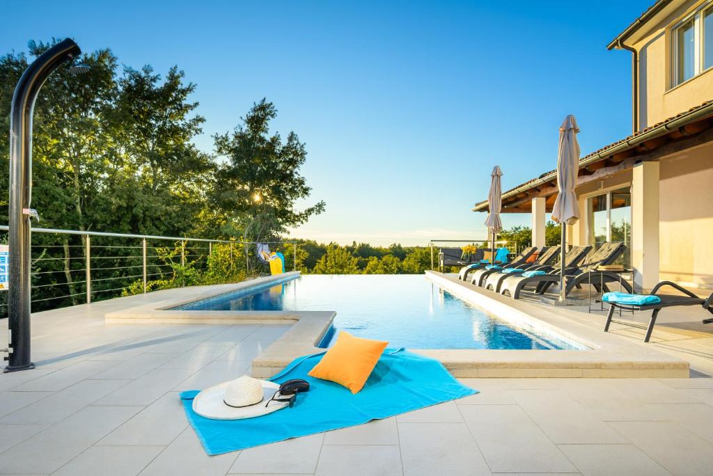 a swimming pool with a pair of flip flops and a pair of sandals at Villa Storia by IstriaLux in Kringa