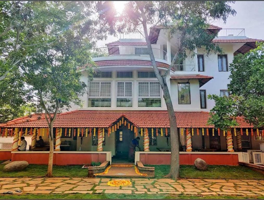 a large white building with a red roof at Sun Farm Retreat in Auroville