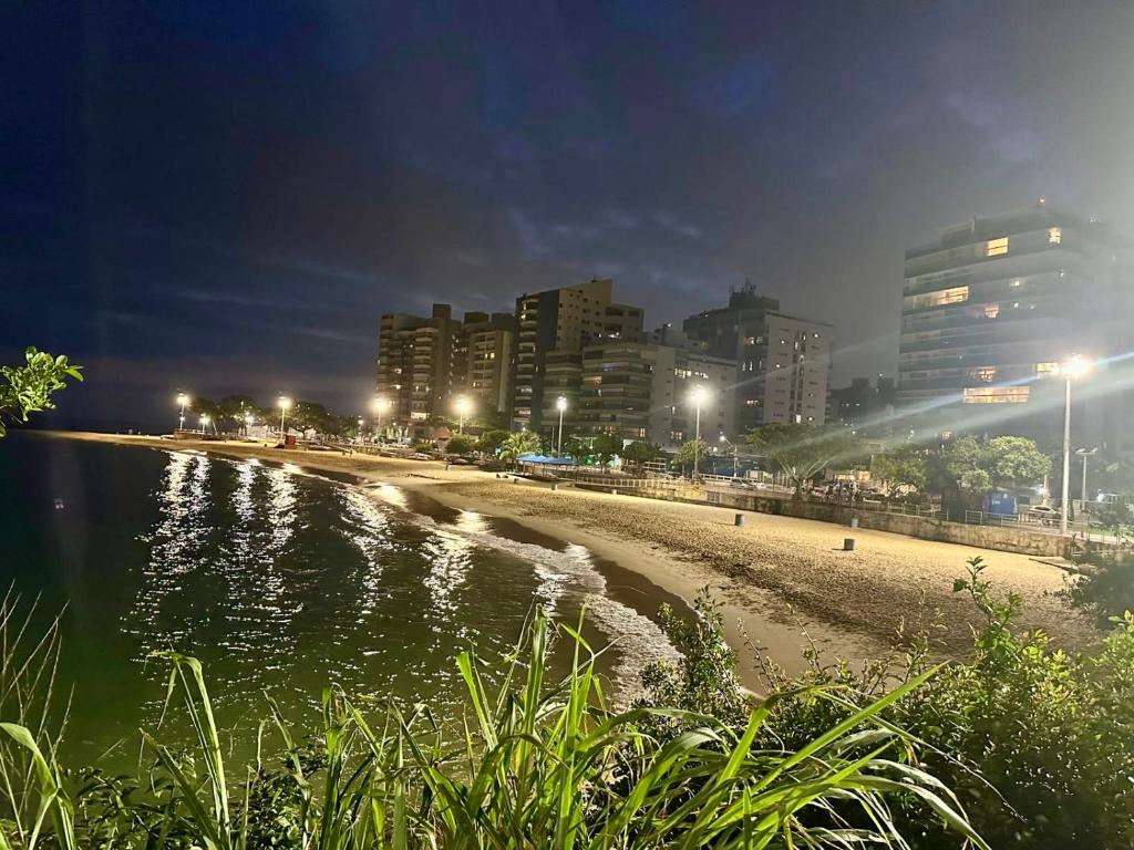 Elegância Praia da Sereia في فيلا فيلها: شاطئ في الليل مع المباني والمدينة