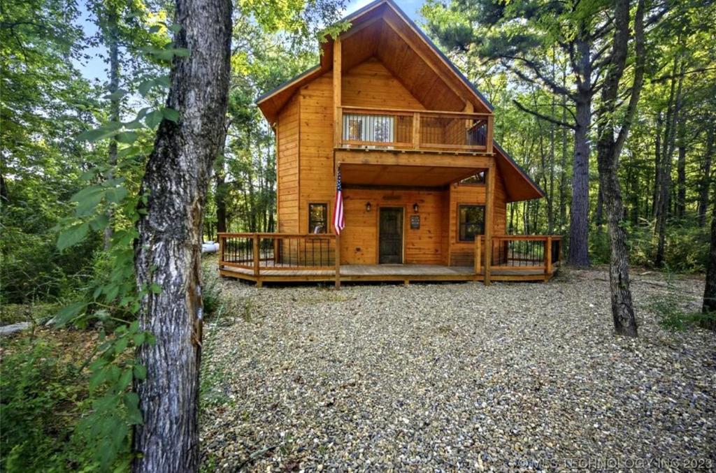 a log cabin in the middle of the woods at Bear with Me Cabin in Broken Bow in Broken Bow