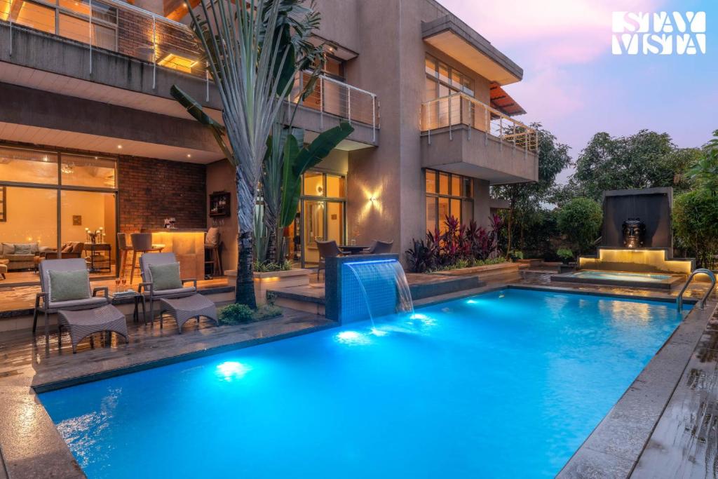a swimming pool in the backyard of a house at StayVista at Belmonte with Bonfire, Jacuzzi in Karjat