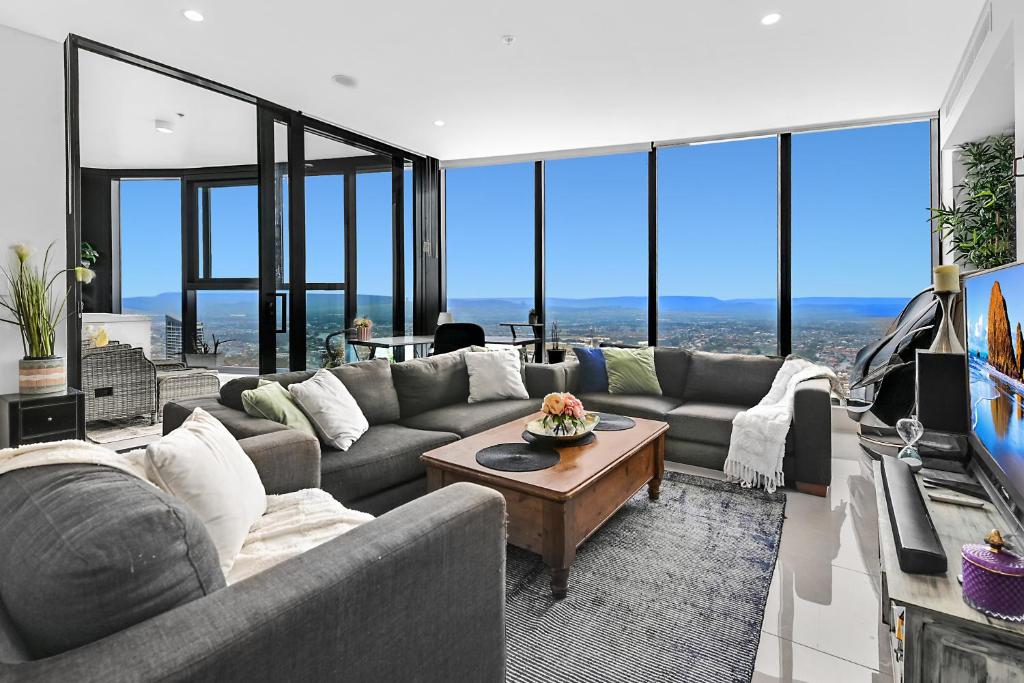 a living room with a couch and a tv at Sky-High Villa with Wide Ocean Views - Pet Friendly in Gold Coast
