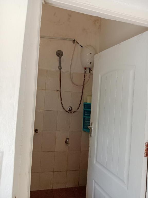 a bathroom with a shower with a shower head at Mombasa Sports Gajoni Spacious 2BR in Mombasa