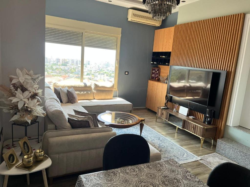 a living room with a couch and a television at Adriatic View Penthouse in Durrës