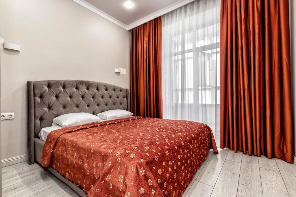 a bedroom with a bed and a large window at Expo Elite Apartments in Astana