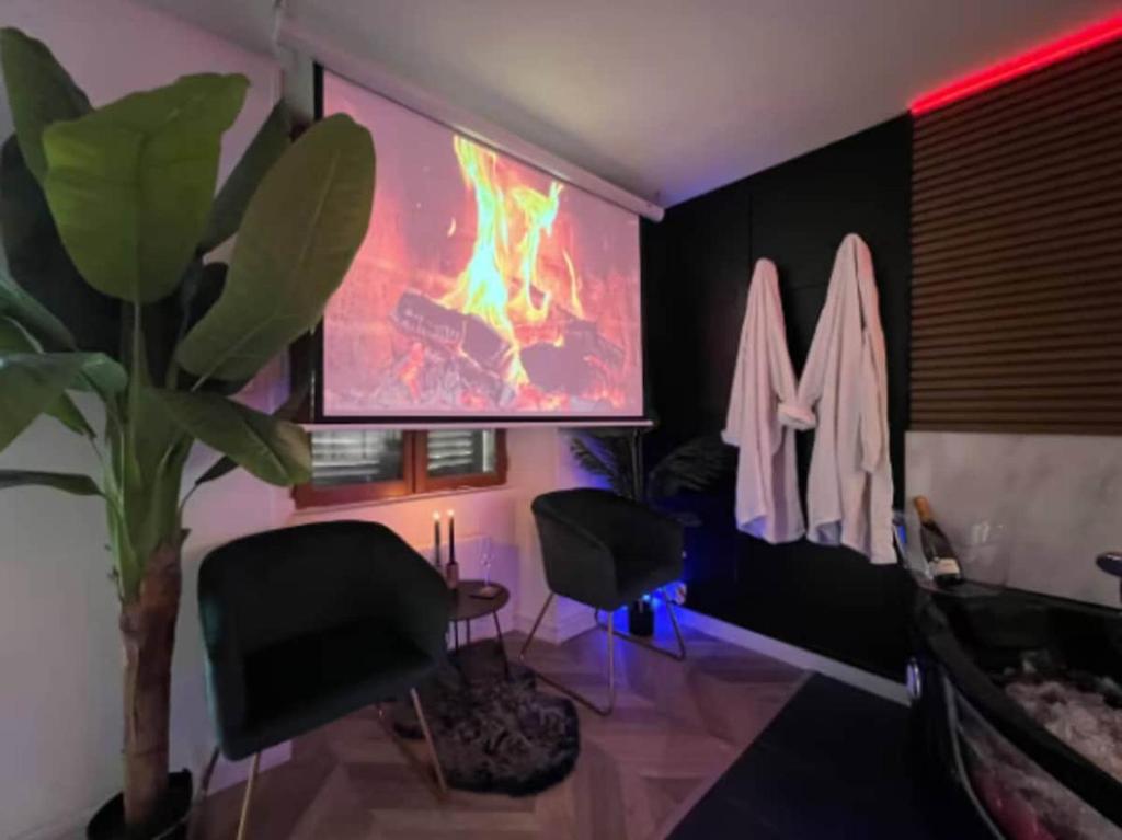 een kamer met 2 stoelen en een schilderij aan de muur bij Secret Room Elegance, mystère et intimité in Souppes-sur-Loing