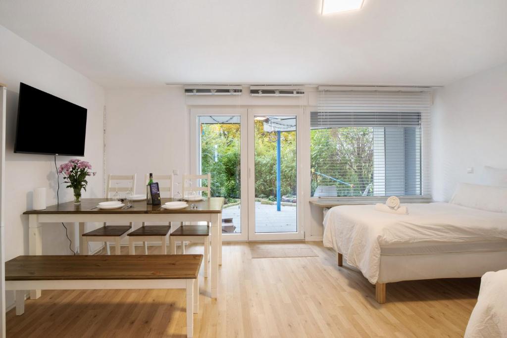 a white bedroom with a bed and a desk and a table at Geschäftsreisetraum mit 6 Betten in Heidenheim