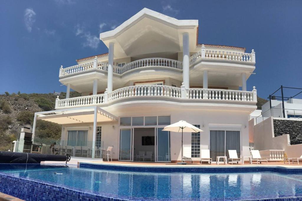 a villa with a swimming pool in front of it at Villa Sunset View Tenerife, Simply Amazing in Adeje