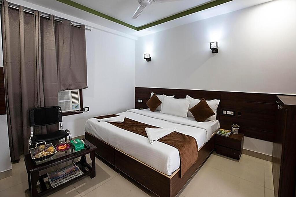 a bedroom with a large bed and a window at HR Grand Hotel in New Delhi