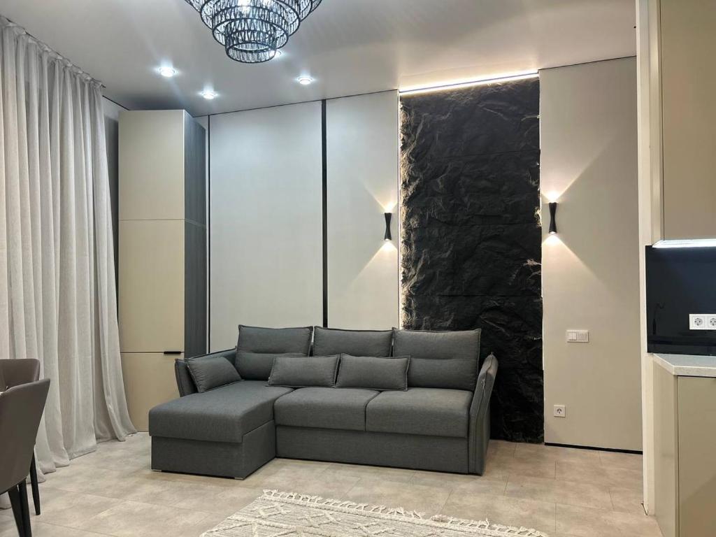 een woonkamer met een bank en een televisie bij ARĞYN Apartments, 3-BR Central in Astana
