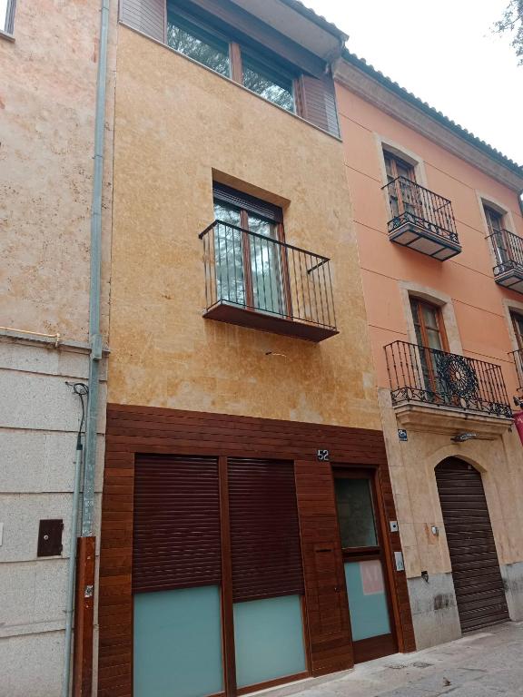 Hotel Apartamentos Living Libreros, a building with two garage doors and two balconies at Apartamentos Living Libreros in Salamanca