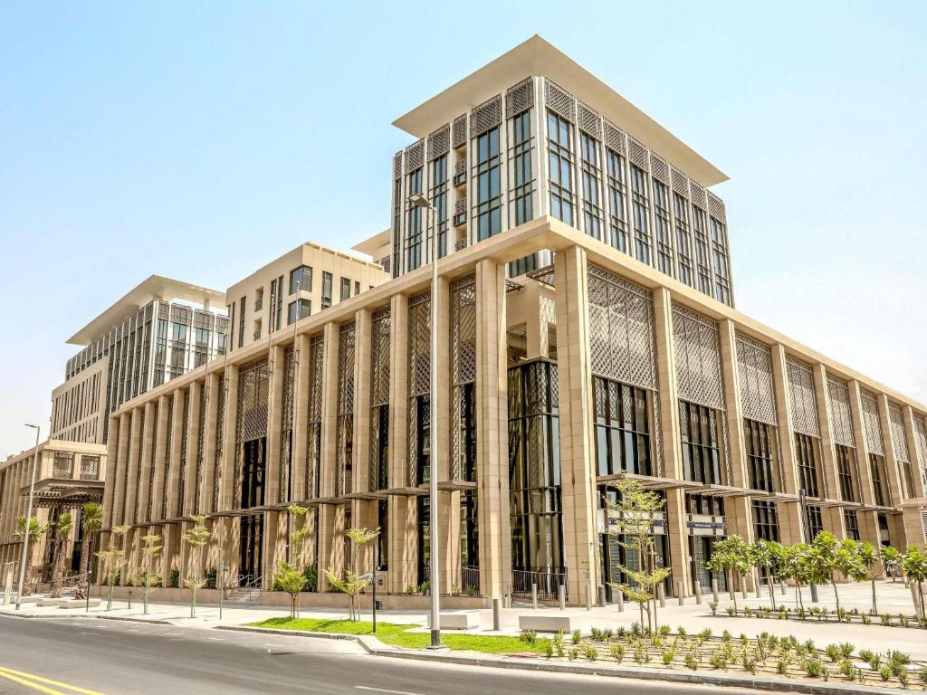 a large building on a street with a road at Mercure Dubai Gold District in Dubai