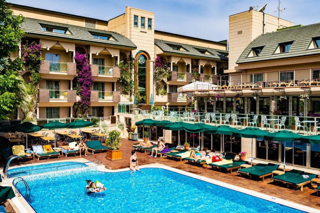 a hotel with a swimming pool in front of a building at AMBAS PLAZA Hotel -All Inclusive Plus in Antalya