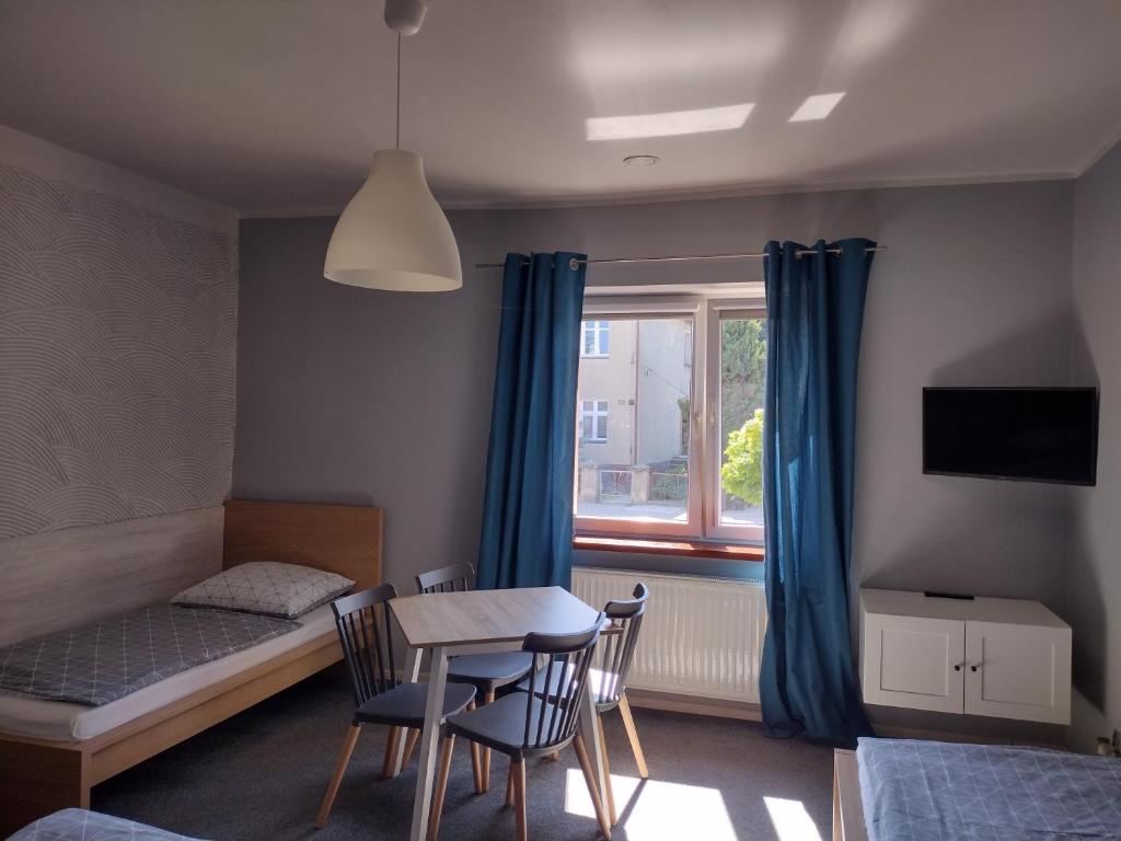 a bedroom with a bed and a table and chairs at Agroturystyka Pod Orzechem in Lubiąż