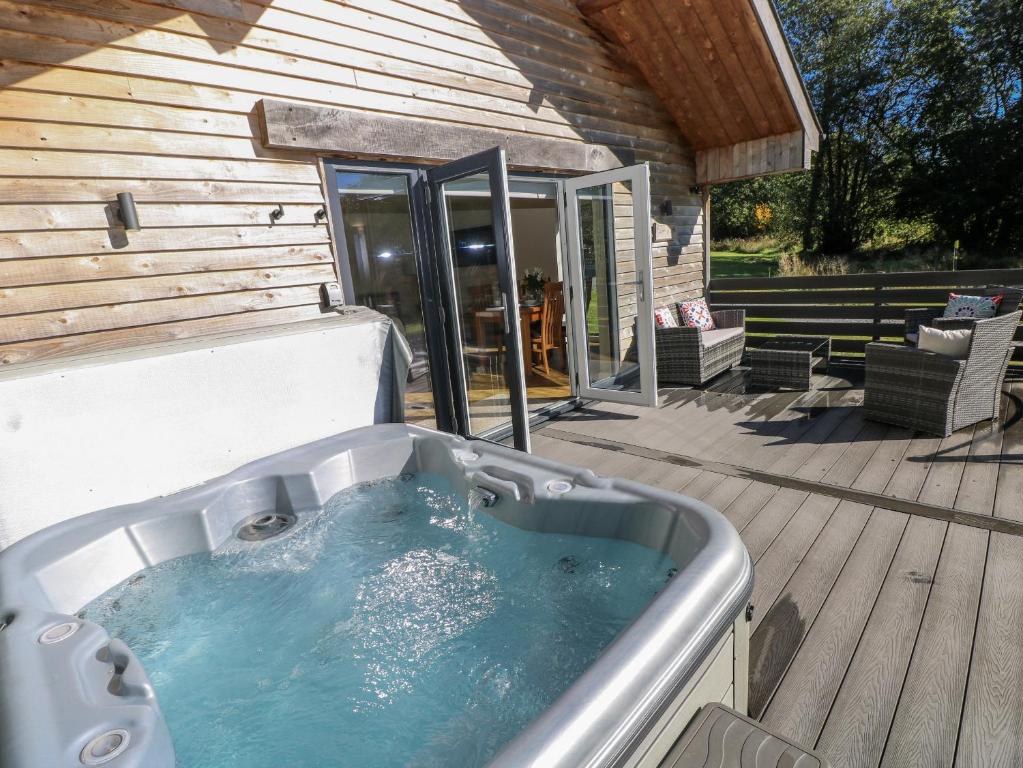 a hot tub on the deck of a house at Dwrgi in Llanybyther