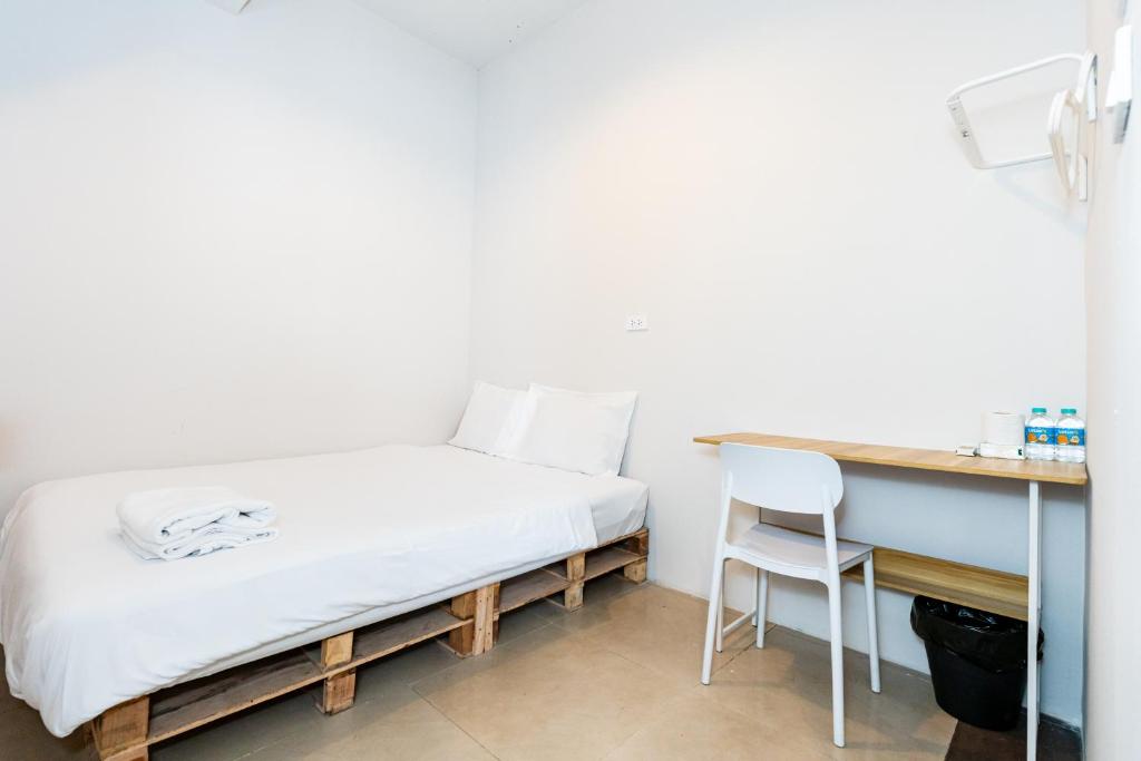a bed in a room with a desk and a chair at X The Hidden Khaosan Road เดอะ ฮิดเด้น ถนนข้าวสาร - รามบุตรี in Bang Bua Thong Railway Station