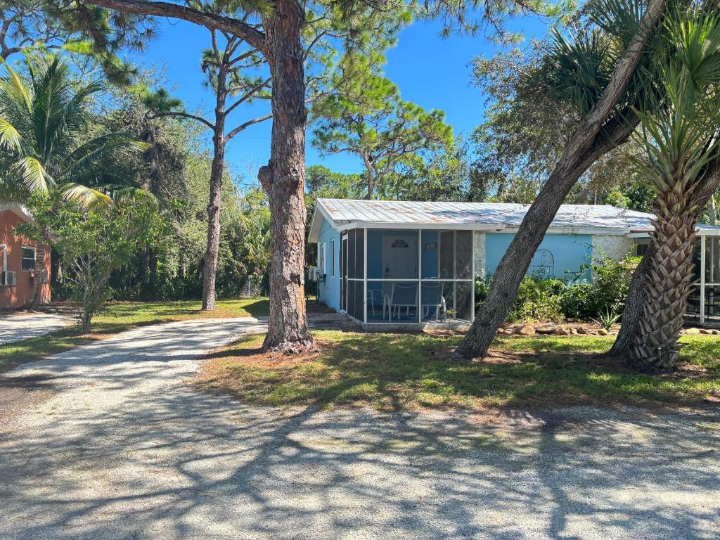 una casa con palmeras delante en Dolphin Updated Cottage On River - 1 Mile to Beach Kitchen Washer Dryer, en Bonita Springs