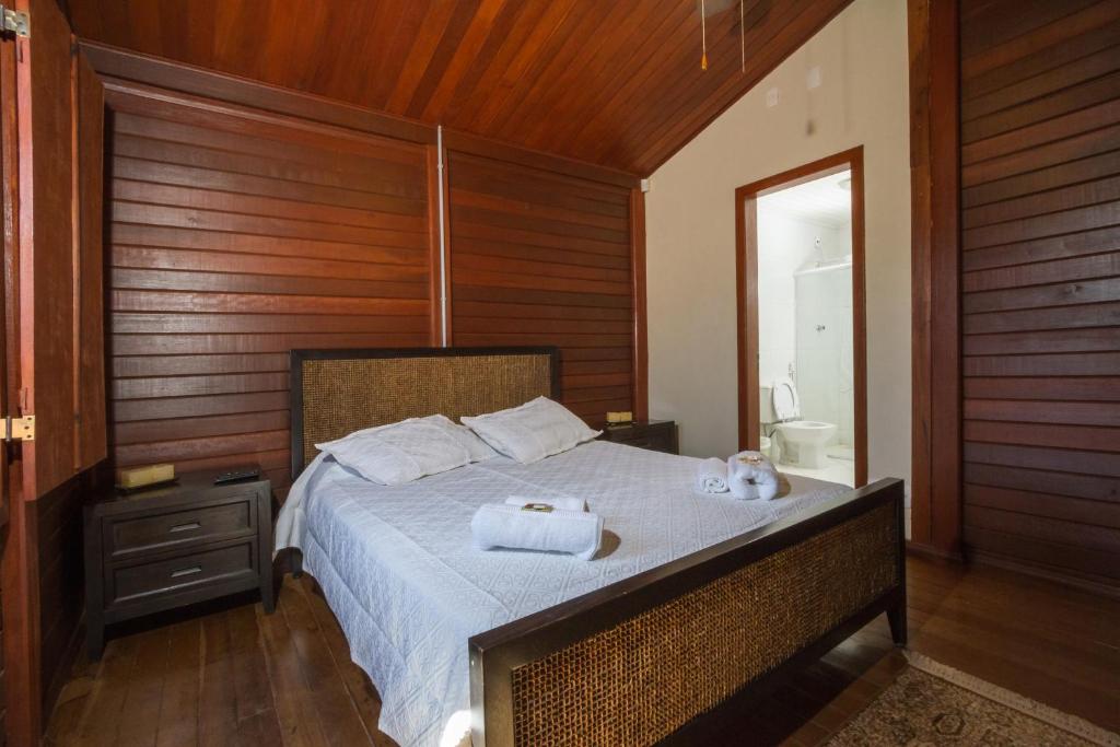 um quarto com uma cama com toalhas em Pousada Recanto Bem Te Vi em Tiradentes