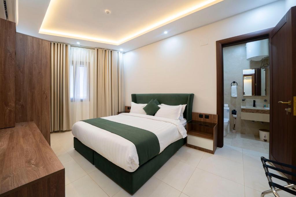 Un dormitorio con una cama grande y un baño. en Aswar Plus, en Tabuk