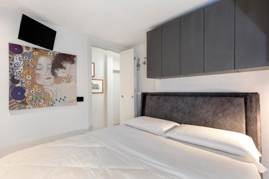 ein Schlafzimmer mit einem Bett und einem Gemälde an der Wand in der Unterkunft Casa Lara e Gaia - Aosta Centro in Aosta