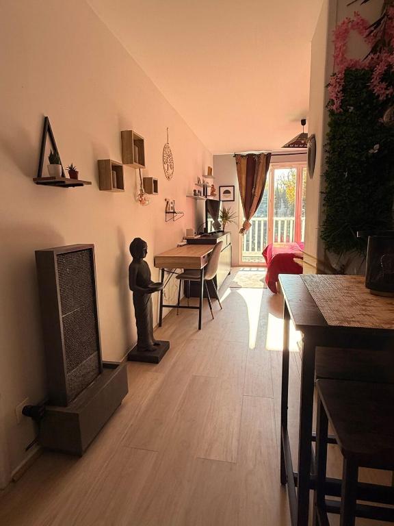 un salon avec une télévision et une table avec une table dans l'établissement Lescale Zen de Bailly, à Bailly-Romainvilliers