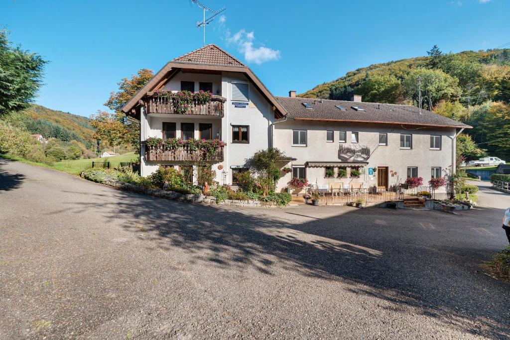 una grande casa bianca con fioriere sul balcone di Pension Schneider a Freiamt