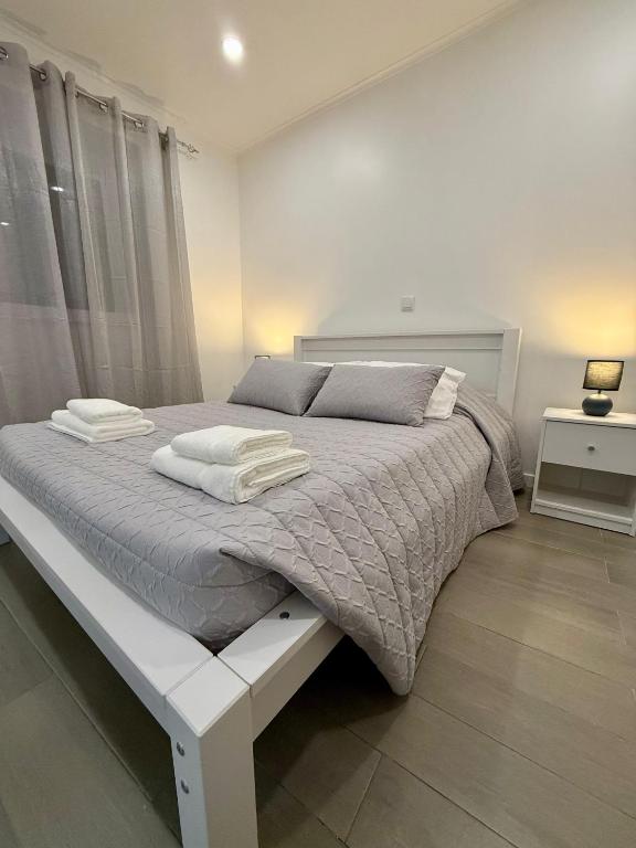 ein weißes Schlafzimmer mit einem großen Bett mit zwei Kissen in der Unterkunft Canto da Maré in Ribeira Grande