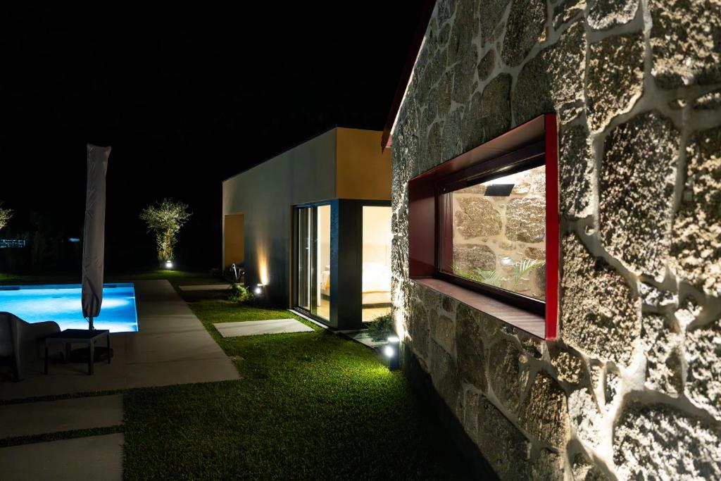 een huis met een tuin met een zwembad in de nacht bij Casa Encosta do Monte in Póvoa de Lanhoso