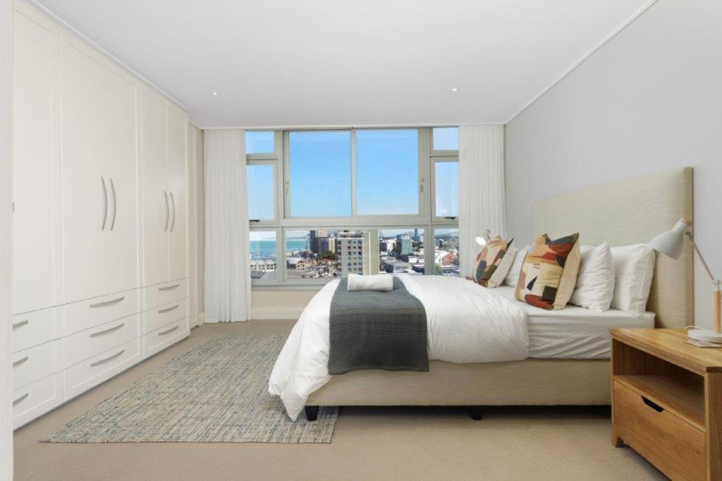 a bedroom with a large bed and a large window at Ashley On Beach 1104 Prestige Style in Strand