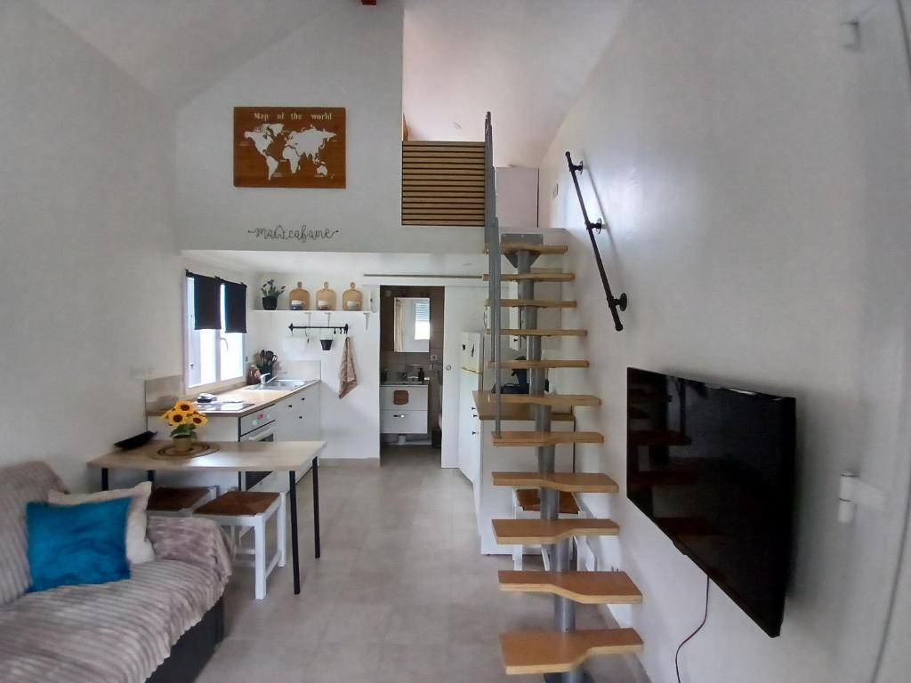 a living room and kitchen with a spiral staircase in a tiny house at Petite Maison in Saint-André-les-Vergers