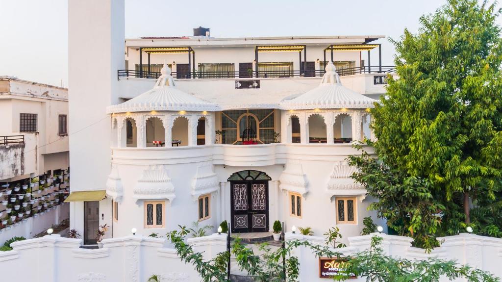 Aara - Boutique stay في أودايبور: مبنى أبيض مع شرفة فوقه